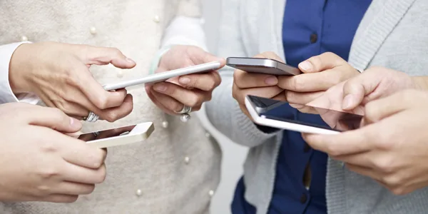 Plusieurs personnes tenant chacune leur téléphone