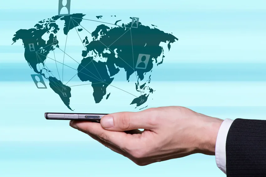 Un smartphone dans une main, relié à un réseau d'appelants répartis dans le monde